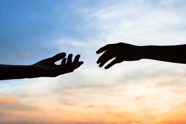 misericordia, silueta de dos manos, concepto de ayuda - humanism fotografías e imágenes de stock