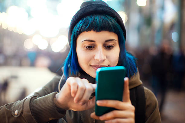 Girl using smartphone Girl with blue hair using smartphone text photography stock pictures, royalty-free photos & images
