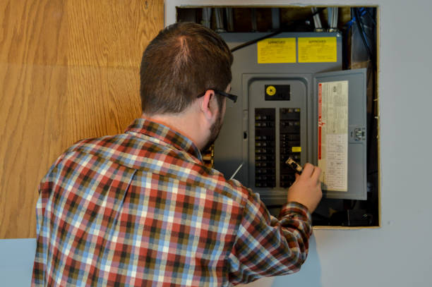 Handyman Inspecting an Electric Box This is an image of a handyman/repairman inspecting an electric box/circuit breaker in a residential home. fuse box stock pictures, royalty-free photos & images