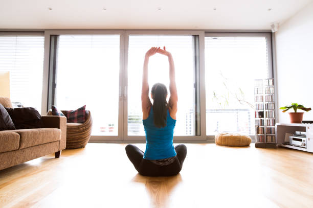 istock Young woman exercising at home, stretching arms. 638898346