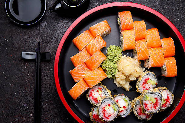 istock Sushi roll on a round wooden plate and stone background. 638898394