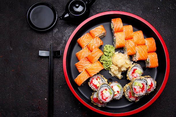 istock Sushi roll on a round wooden plate and stone background. 638898468
