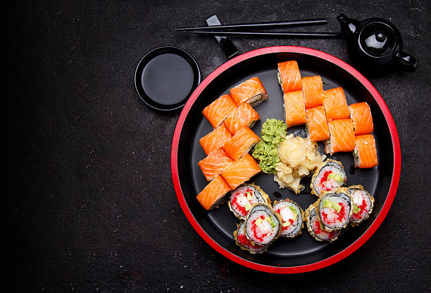 istock Sushi roll on a round wooden plate and stone background. 638898546