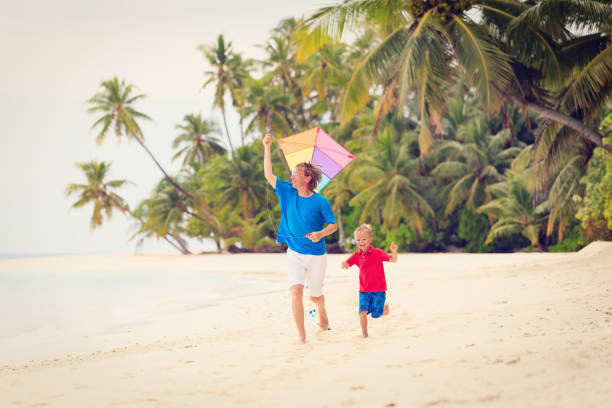 istock father and little son flying kite on beach 638898610