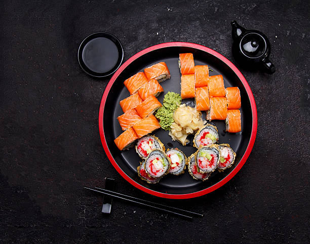 istock Sushi roll on a round wooden plate and stone background. 638898628
