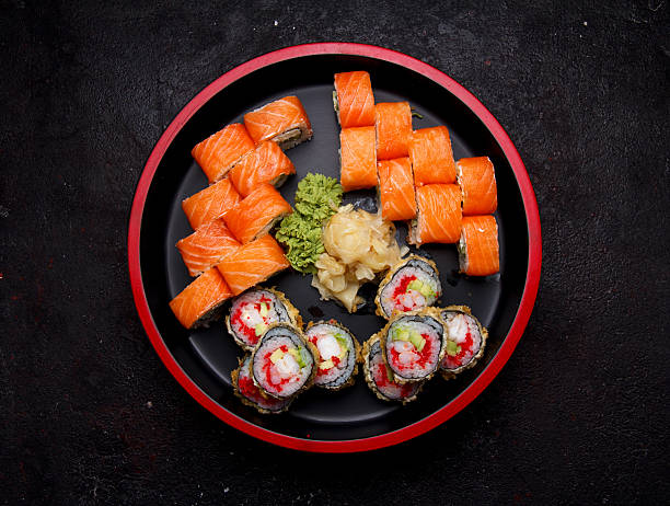 istock Sushi roll on a round wooden plate and stone background. 638898700