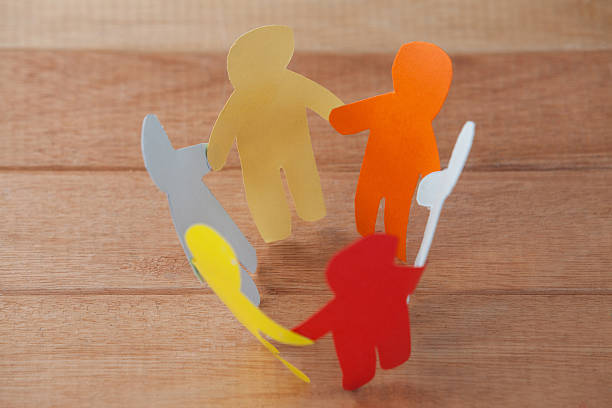 istock Multicolored paper cut outs forming a circle on wooden background 638900760