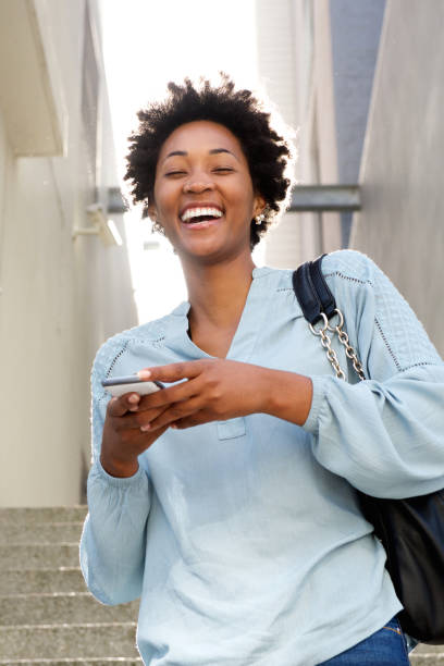 istock Laughing young african lady with mobile phone 638901974