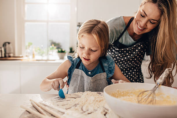 istock Mother teaching her daughter to cook in kitchen 638902084