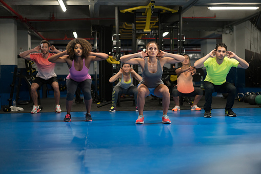 Latin American group of people at the gym exercising in an aerobics class - healthy lifestyle concepts