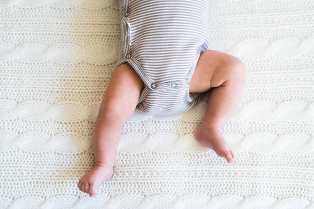 Unrecognizable baby boy lying on bed, close up