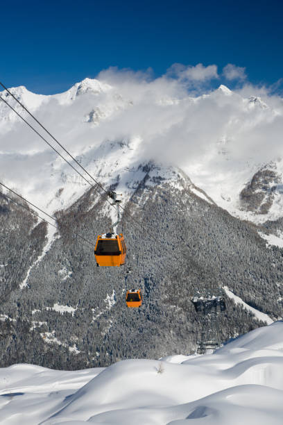 istock Winter, snow covered mountain with cable cars, sky, clouds 638905596