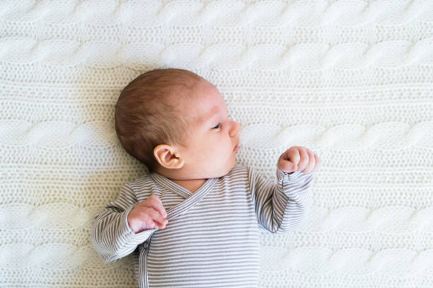 istock Cute newborn baby boy lying on bed, close up 638905624