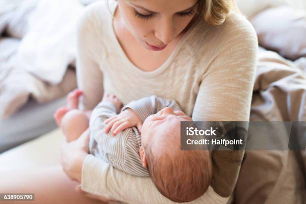 Beautiful Young Mother Holding Baby Son In Her Arms Stock Photo - Download Image Now