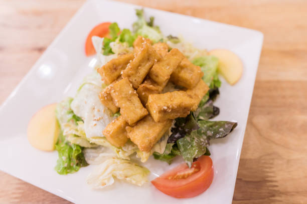 istock Tofu salad on white plate over wooden background. 638905830