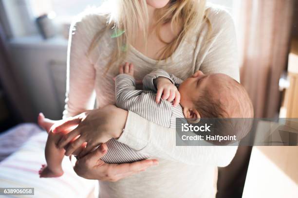 Unrecognizable Young Mother Holding Baby Son In Her Arms Stock Photo - Download Image Now