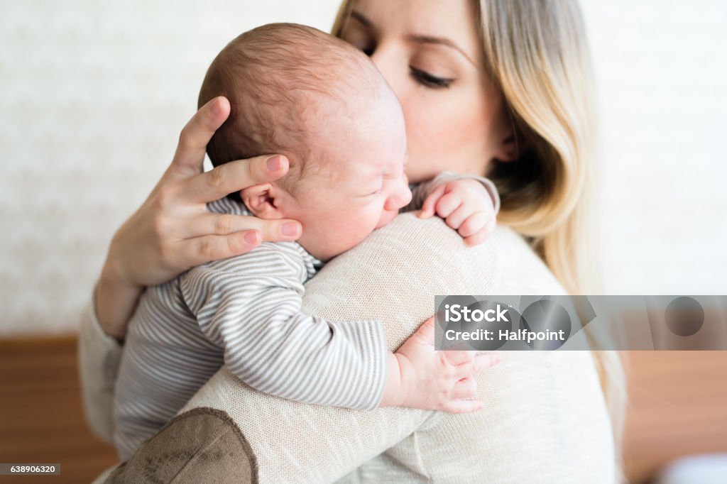 Beautiful young mother holding baby son in her arms Beautiful young mother holding her baby son in her arms Baby - Human Age Stock Photo