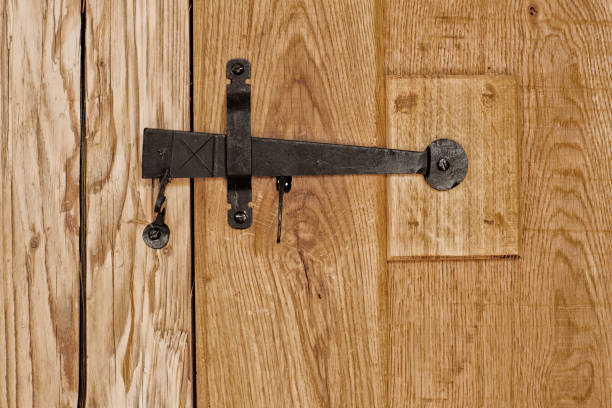 istock Rustic wooden door with hammered old fashioned iron lock 638906356