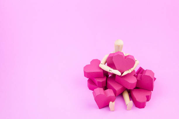 istock Wooden dummy holding paper box red heart shape 638909288