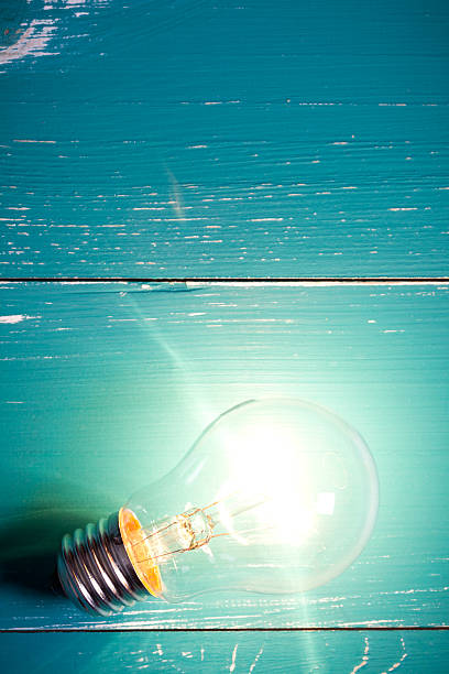 istock Vintage incandescent bulb on turquoise wooden table 638909594