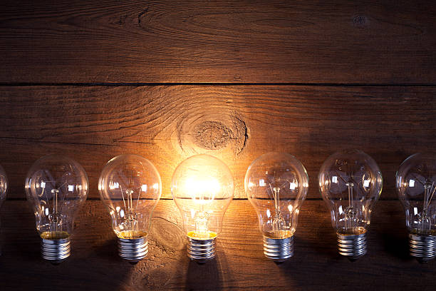 istock Vintage incandescent bulbs on old wooden table 638909704