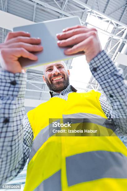 Engineer Using A Digital Tablet Low Angle View Stock Photo - Download Image Now - Adult, Adults Only, Airplane Hangar