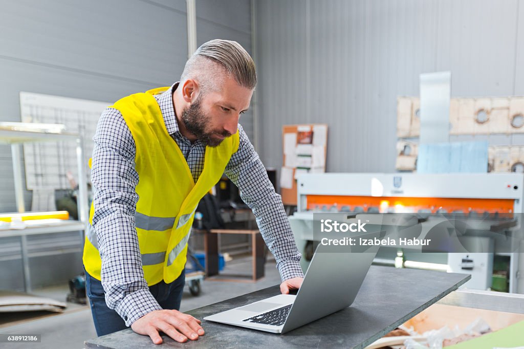 Engineer using a laptop at work Construction engineer using a computer at work.  Adult Stock Photo