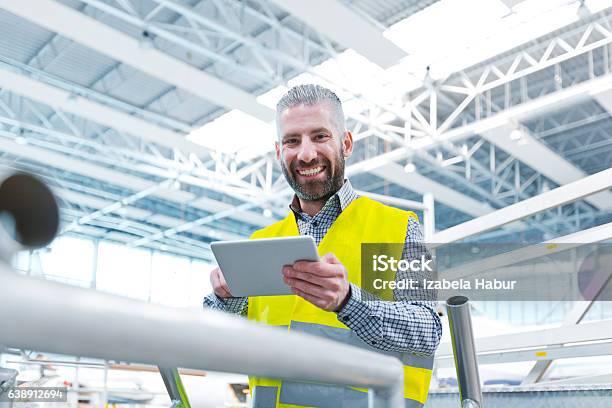 Aircraft Engineer Using A Digital Tablet In A Hangar Stock Photo - Download Image Now