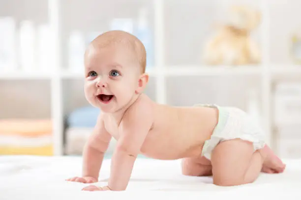 Photo of Adorable crawling baby on white blanket