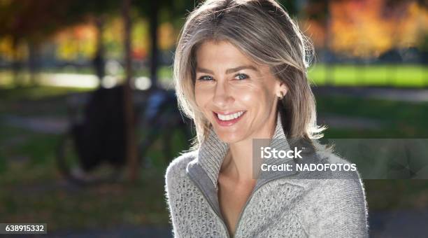 Portrait Of A Mature Woman Smiling At The Camera Outside Stock Photo - Download Image Now