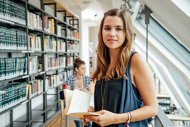 istock student with book standing against friends in corridor 638921074