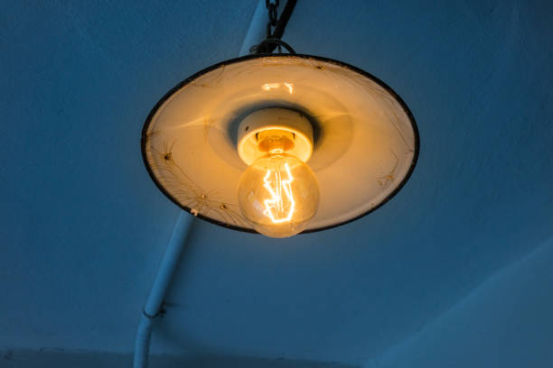 istock Lighting light bulb on the cable in dark room 638921130