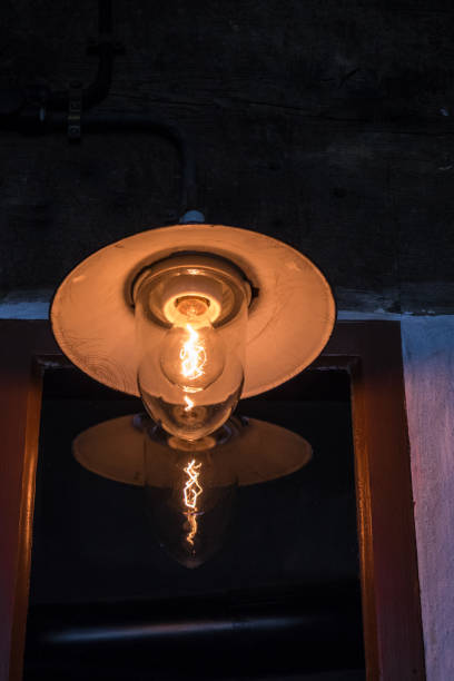 istock Lighting light bulb on the cable in dark room 638921230