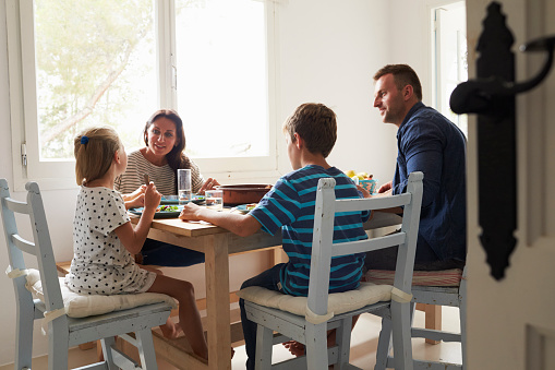 Family At Home In Eating Meal Together