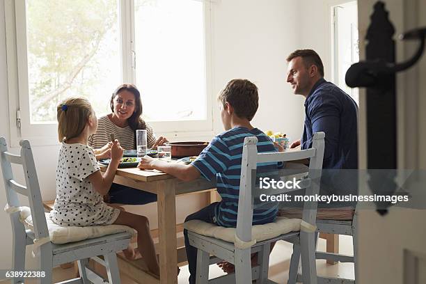 Family At Home In Eating Meal Together Stock Photo - Download Image Now - Family, Dinner, Eating