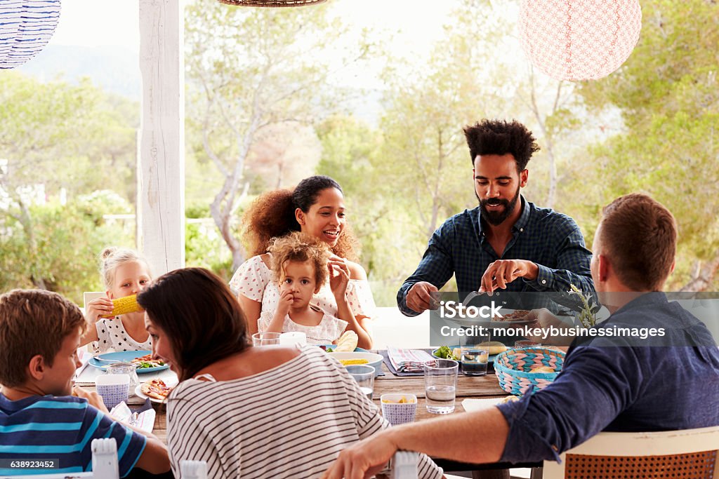 Families Enjoying Outdoor Meal On Terrace Together Family Stock Photo