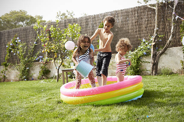 istock Children Having Fun In Garden Paddling Pool 638923566