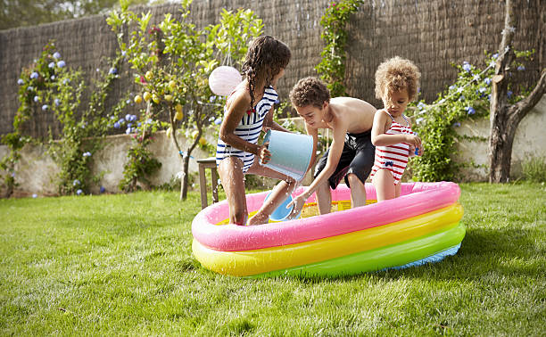 istock Children Having Fun In Garden Paddling Pool 638923576
