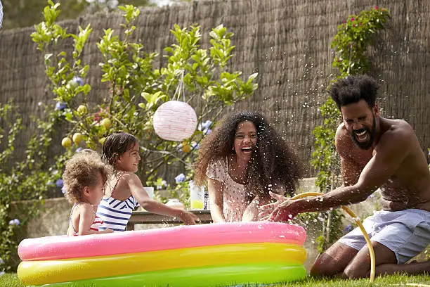 Photo of Family Having Fun In Garden Paddling Pool