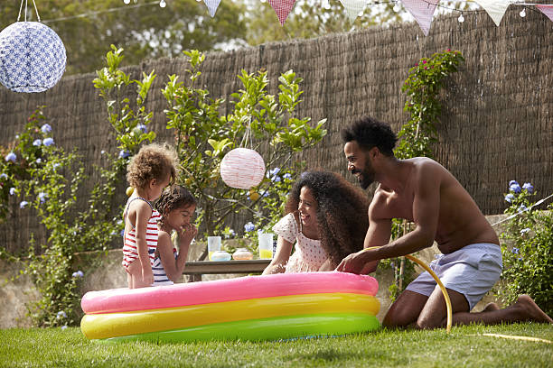 istock Family Having Fun In Garden Paddling Pool 638923596