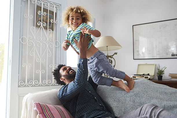 istock Father And Son Playing Game On Sofa Together 638923628