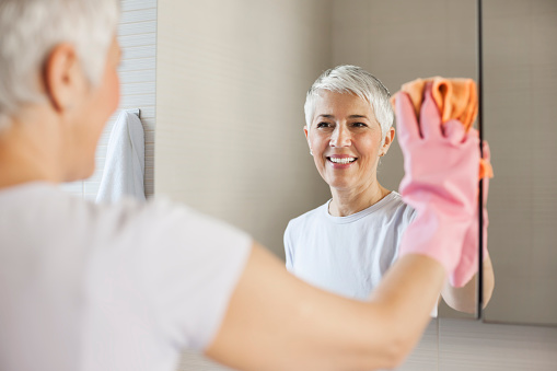 Mature woman cleaning home