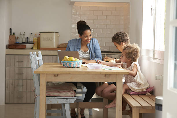 istock Children Paint At Kitchen Table As Mother Works At Laptop 638923812