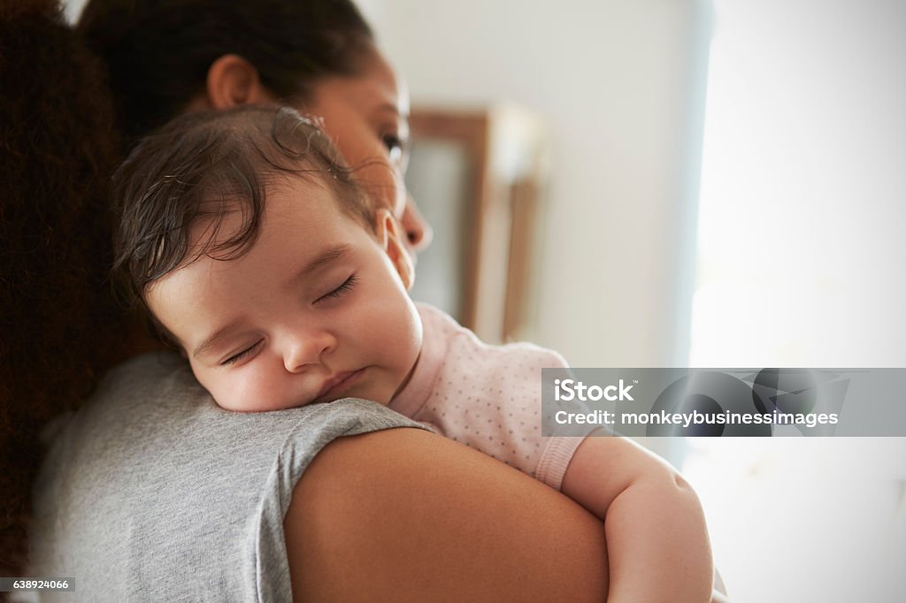 Primer plano de la madre abrazando a la hija dormida en casa - Foto de stock de Bebé libre de derechos