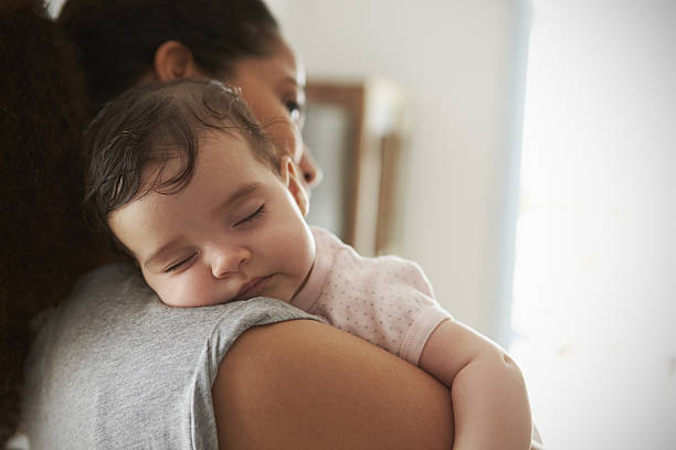 primer plano de la madre abrazando a la hija dormida en casa - baby fotografías e imágenes de stock