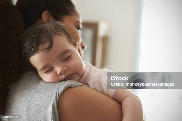 Primer Plano De La Madre Abrazando A La Hija Dormida En Casa Foto de stock y más banco de imágenes de Bebé