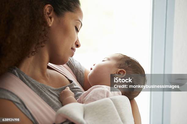 Primer Plano De La Madre Abrazando A La Hija En Casa Foto de stock y más banco de imágenes de Bebé