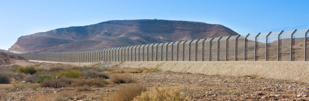 Israel Egypt border fence in the Negev and Sinai deserts The new border fence between Israel (Negev Desert) and Egypt (Sinai Desert) international border barrier stock pictures, royalty-free photos & images