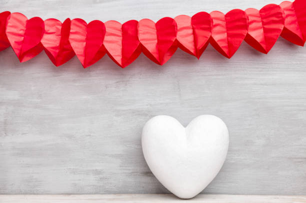 Love concept. Hearts hanging on grey rustic background