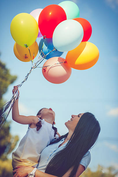 istock Mother and daughter with balloons 638931284